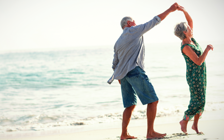 Senior couple dancing joyfully on the beach