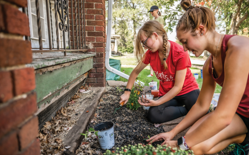 Happy college students gardening on the ground.