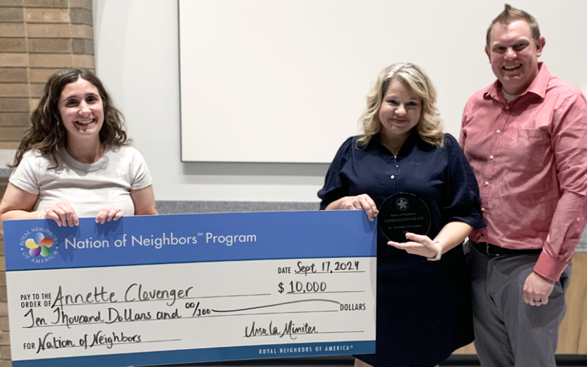 Three happy people holding a large Nation of Neighbors $10,000 check.