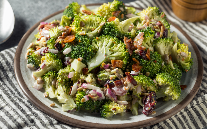 Close up of broccoli salad on a plate on a striped placemat.